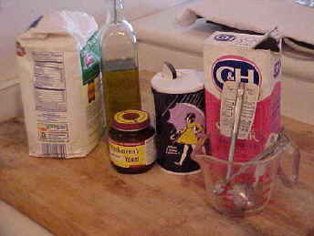 Ingredients for pizza: flour, olive oil, Fleischmann's yeast, salt, sugar, thermometer and cup.